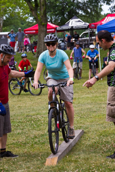 Rider learning to navigate a simulated trail obstacle during a Mountain Biking 101 skills clinic.